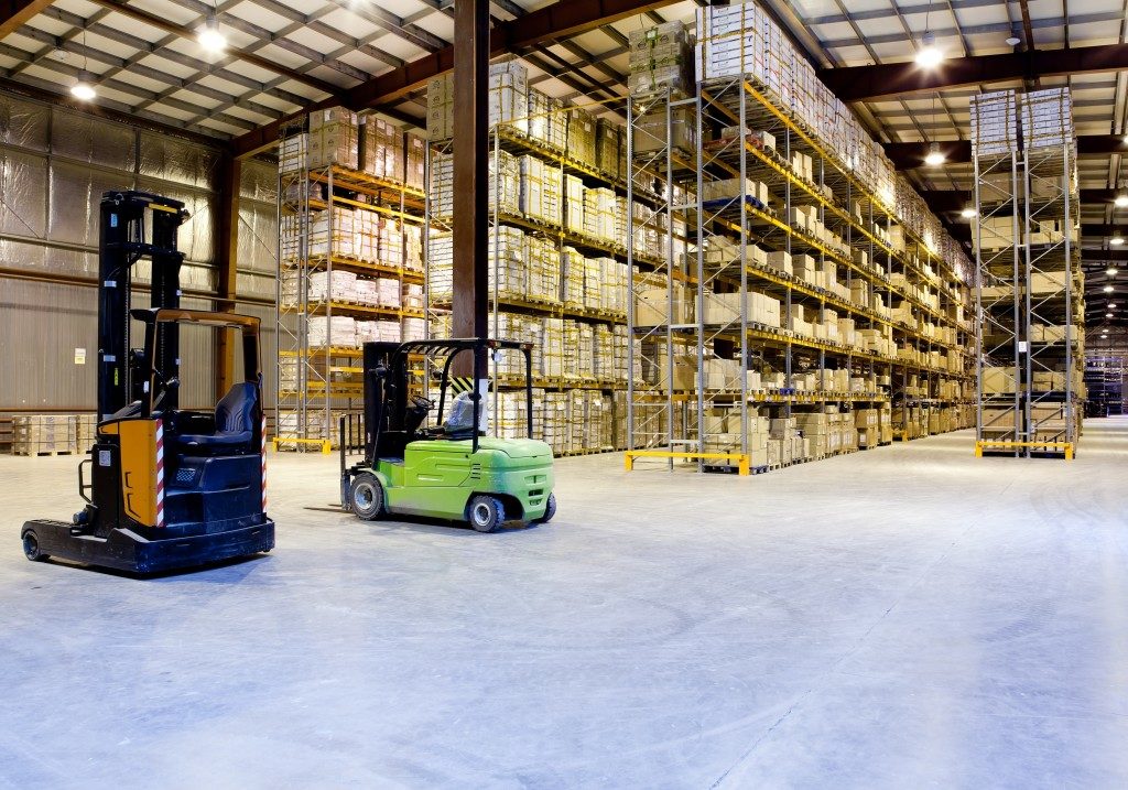 Warehouse with orange and green forklifts