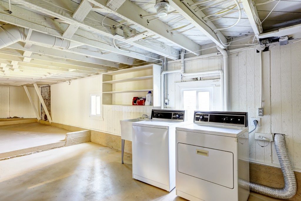 Spacious empty basement with laundry machine in american house