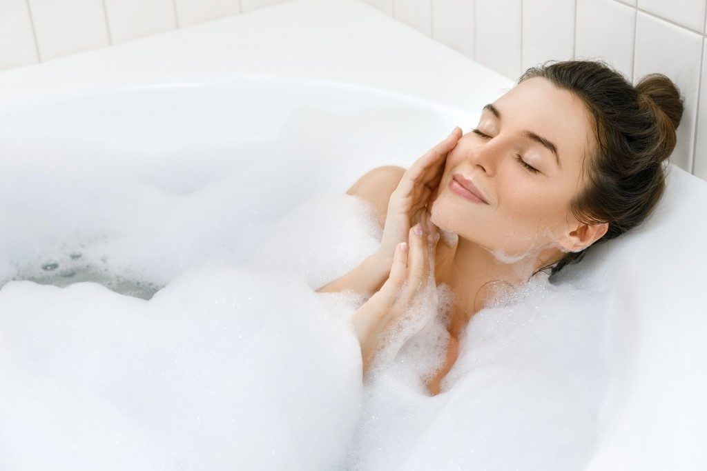 woman enjoying relaxing bath at home