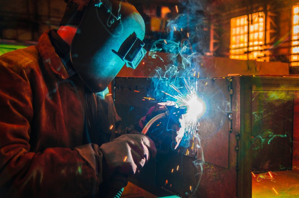 Man-welding-metal-while-wearing-safety-helmet
