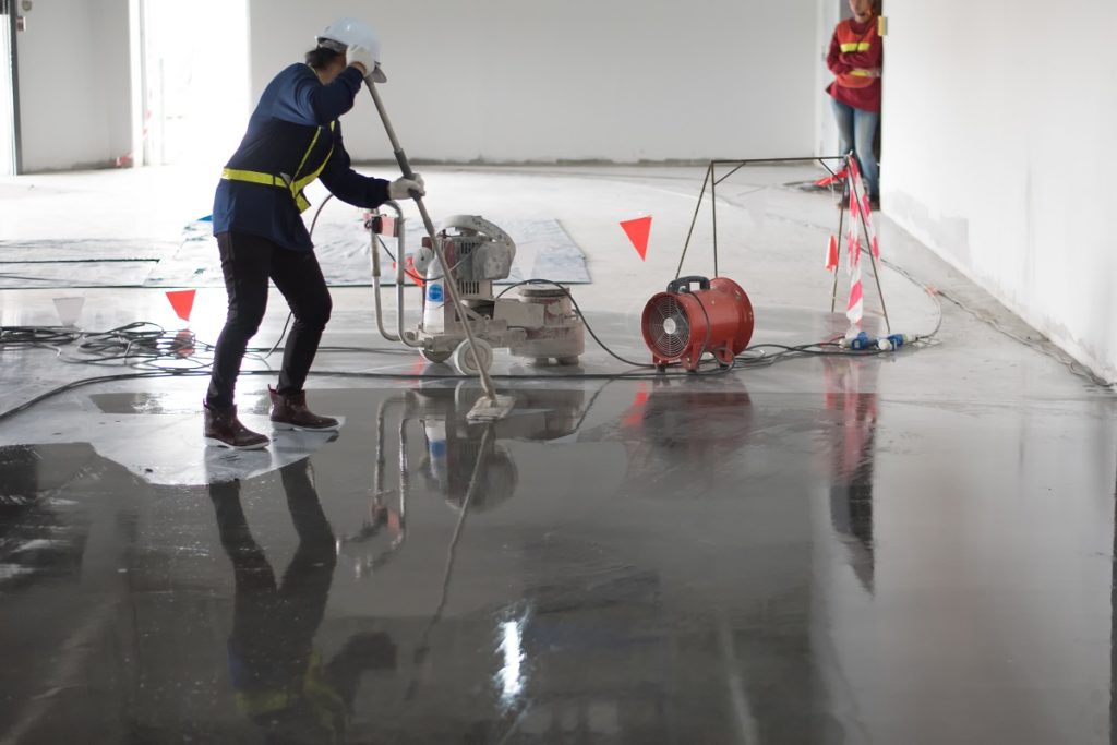 construction applying epoxy on the floor