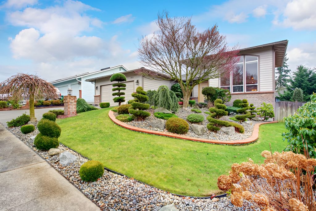 front yard with shrubs, trees, flowers, and rocks